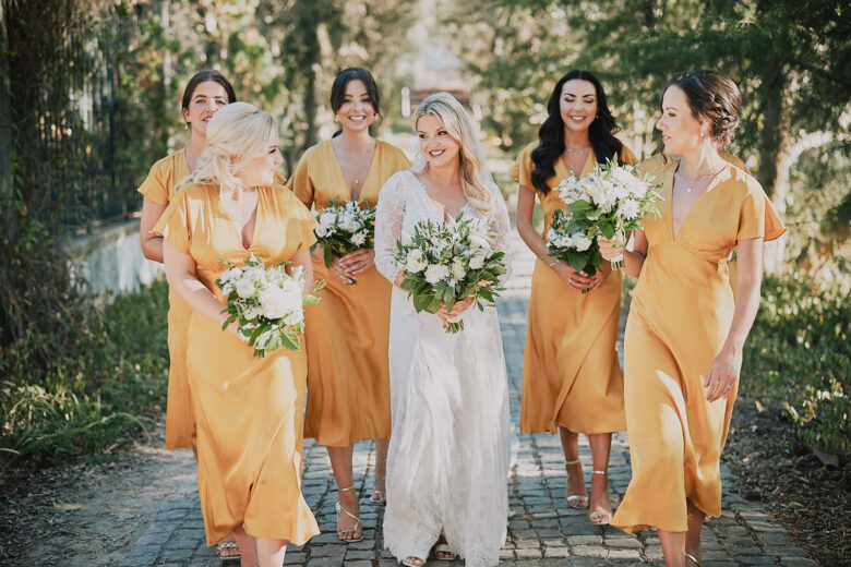 Bride walking with her bridesmaids while holding their flowers