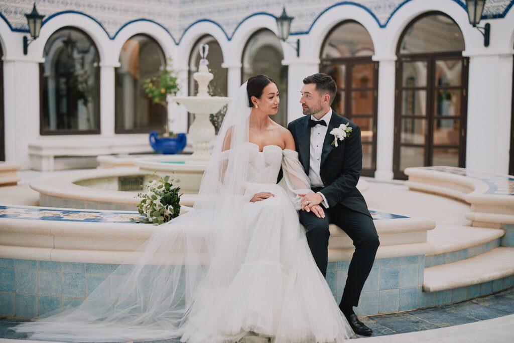 Bride and groom sitting by the fountain