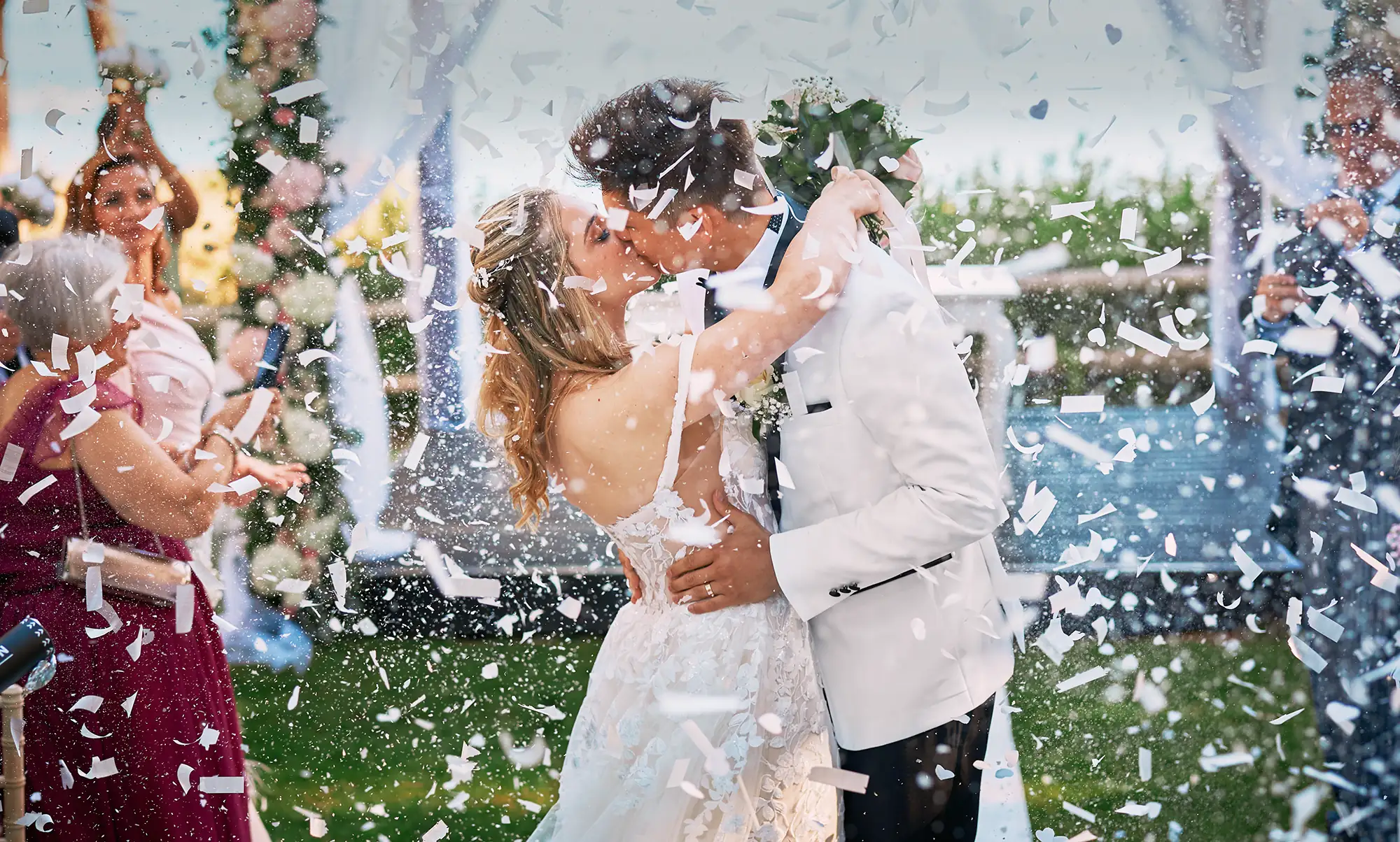 Brautpaar küsst sich nach der Trauung im Konfettiregen bei einer Hochzeit an der Algarve