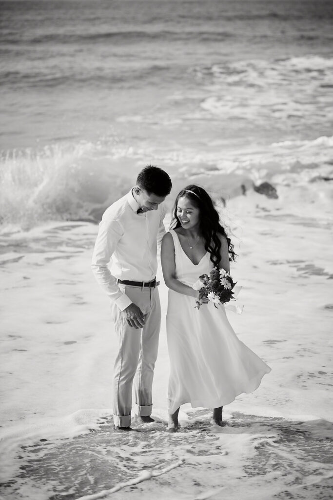 Brautpaar genießt die Wellen bei einer Hochzeit zu zweit an der Algarve in Portugal