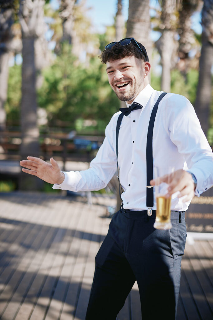 Gut gelaunter Hochzeitsgast mit Getränk bei der Feier im Vidamar Resort Algarve