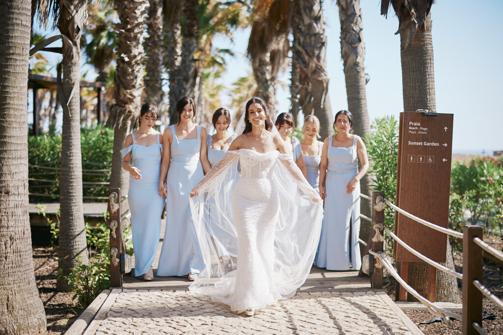 Braut mit ihren Brautjungfern auf einem Palmenweg im Vidamar Resort Algarve