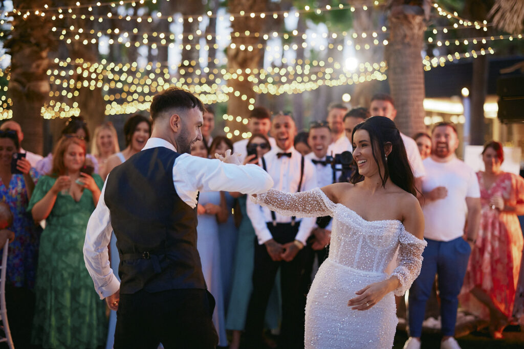 Brautpaar tanzt am Abend bei der Hochzeitsfeier im Vidamar Resort Algarve zwischen Palmen