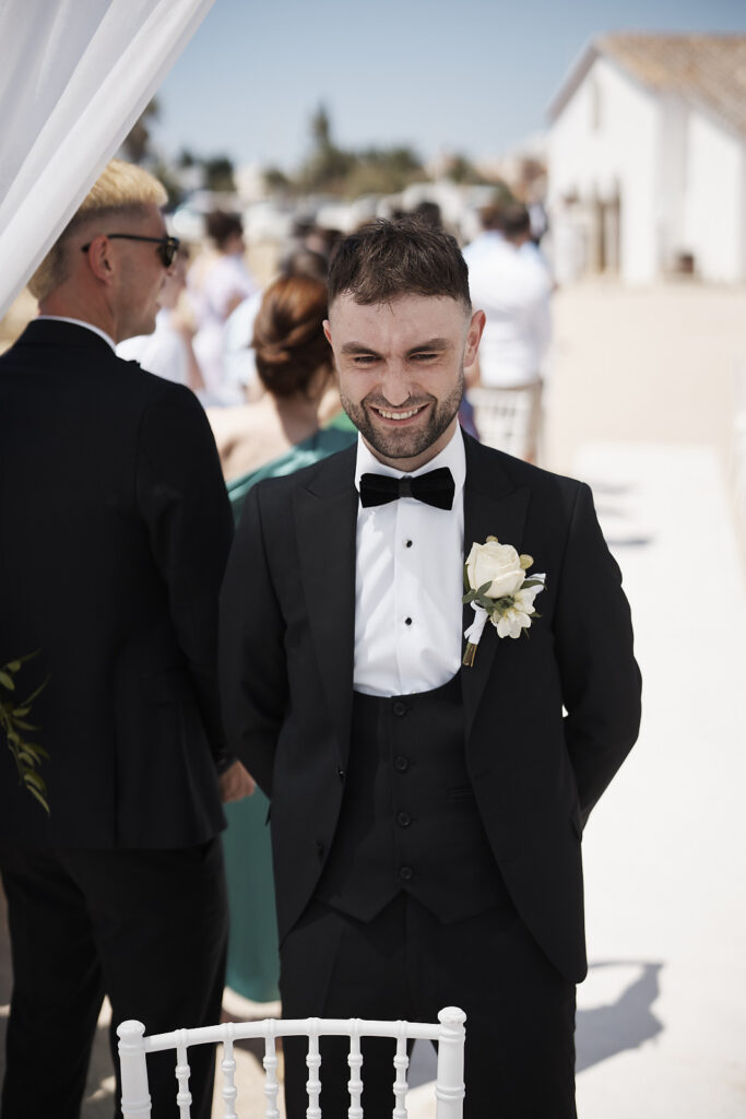 Bräutigam wartet lächelnd vor der Trauung in Senhora da Rocha an der Algarve