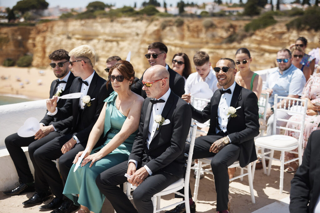Hochzeitsgäste sitzen während der Zeremonie in Senhora da Rocha an der Algarve