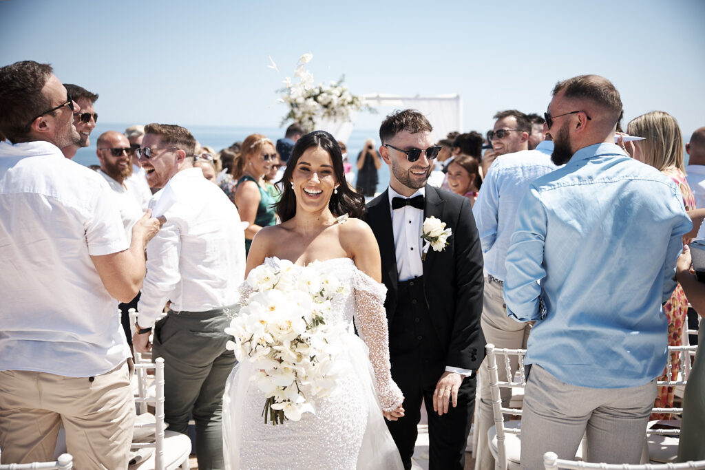 Braut und Bräutigam nach der Trauung in Senhora da Rocha an der Algarve zwischen ihren Gästen