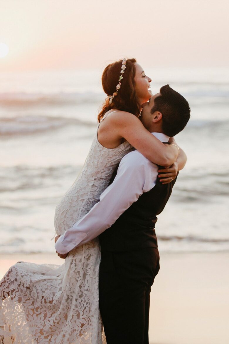 Couple embracing at sunset during an intimate beach elopement in the Algarve, Portugal