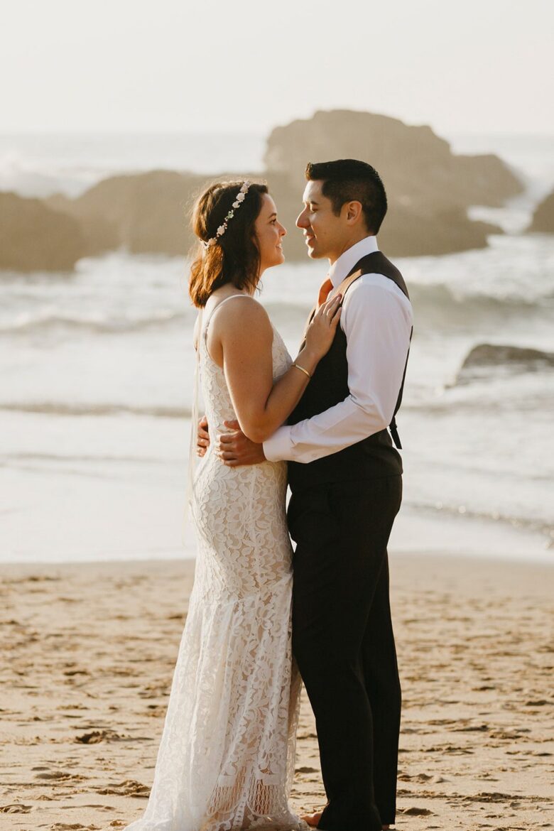 Bride and groom standing together on a quiet beach during their Algarve elopement in Portugal
