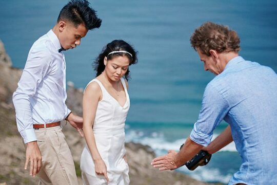 Algarve elopement photographer guiding couple during portraits on coastal cliffs in Portugal