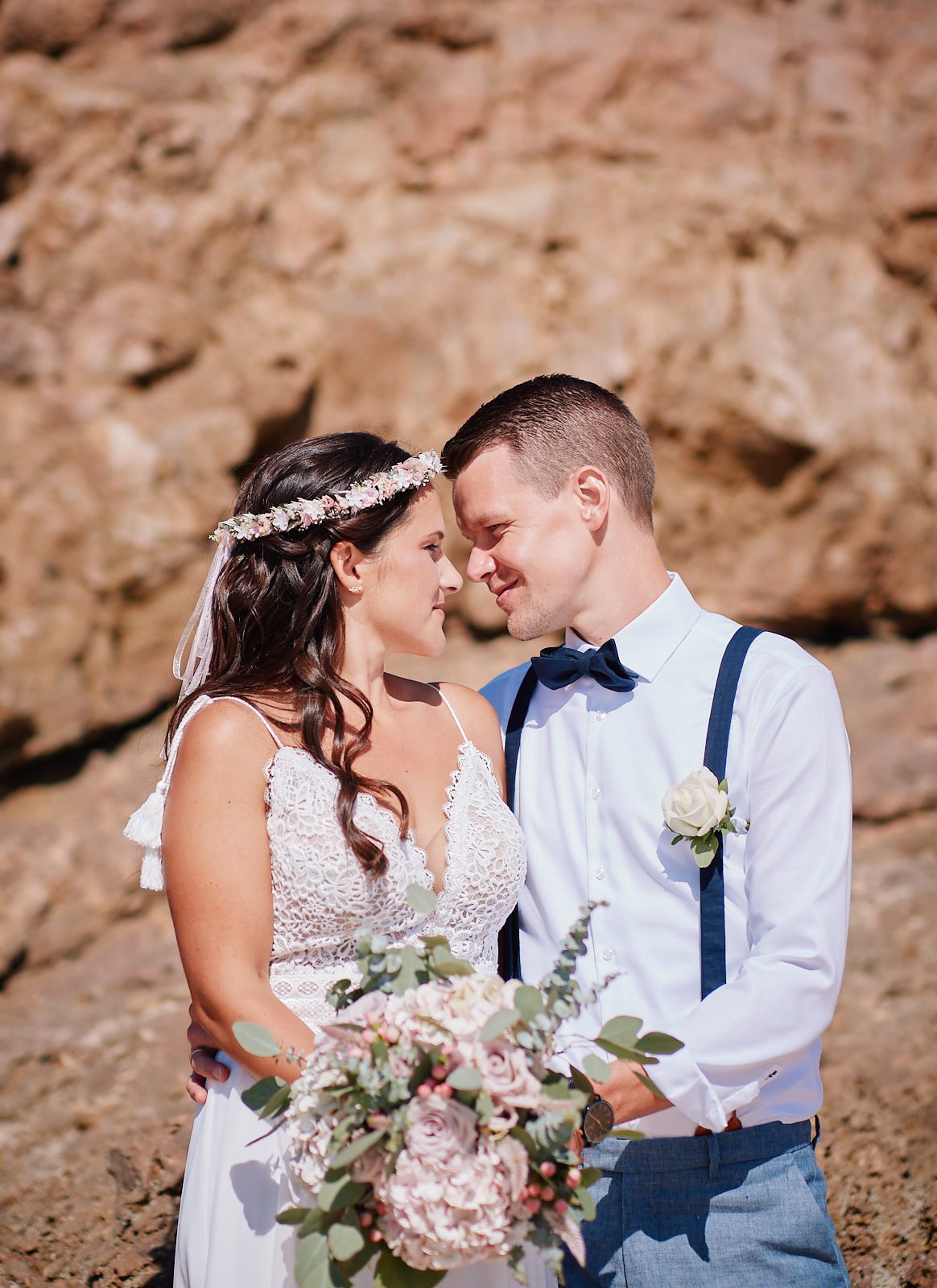 Brautpaar Portrait nach einer Strandhochzeit an der Algarve vor Felsen am Strand
