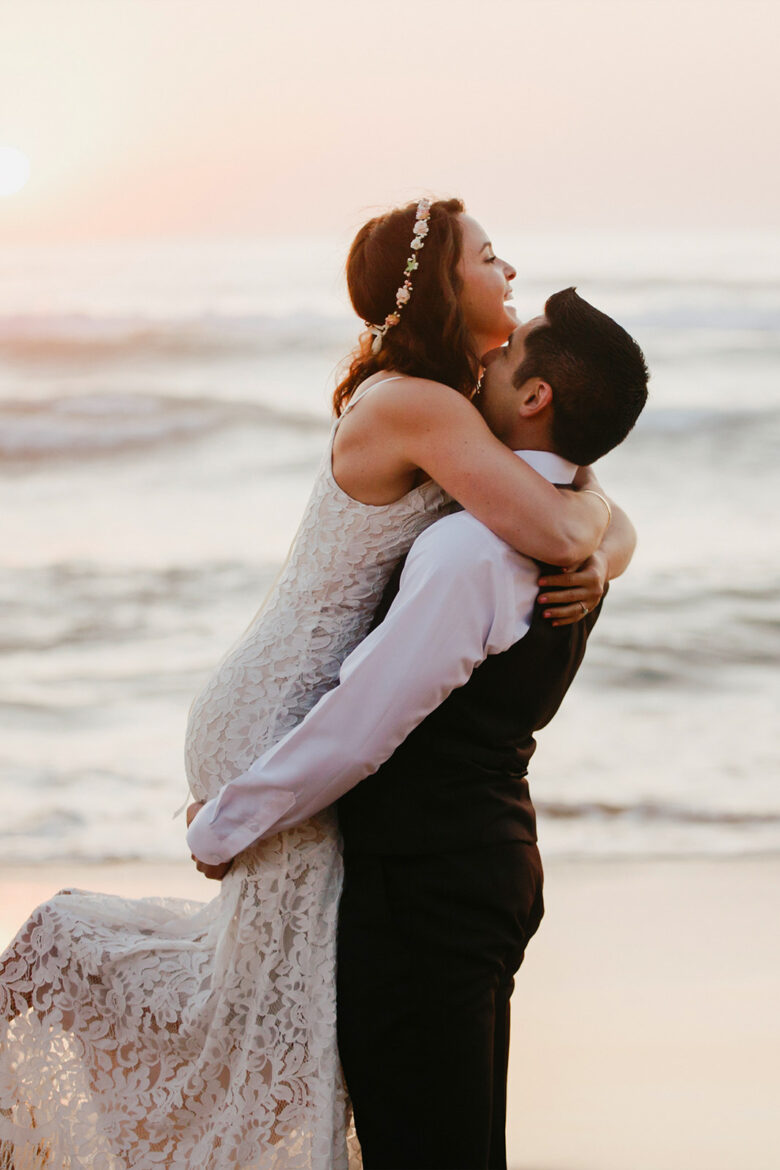 Brautpaar bei einer Hochzeit zu zweit am Strand der Algarve bei Sonnenuntergang in Portugal