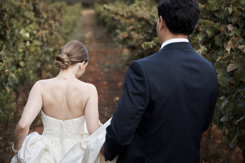 Braut und Bräutigam gehen gemeinsam durch die Weinreben auf dem Weingut Arvad in der Algarve
