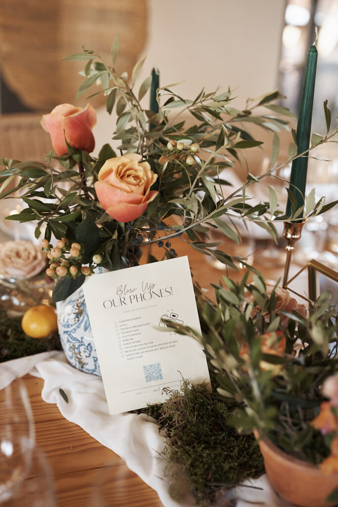 Florale Tischdekoration mit Schild Blow Up Our Phones auf einer Hochzeit im Weingut Arvad in der Algarve