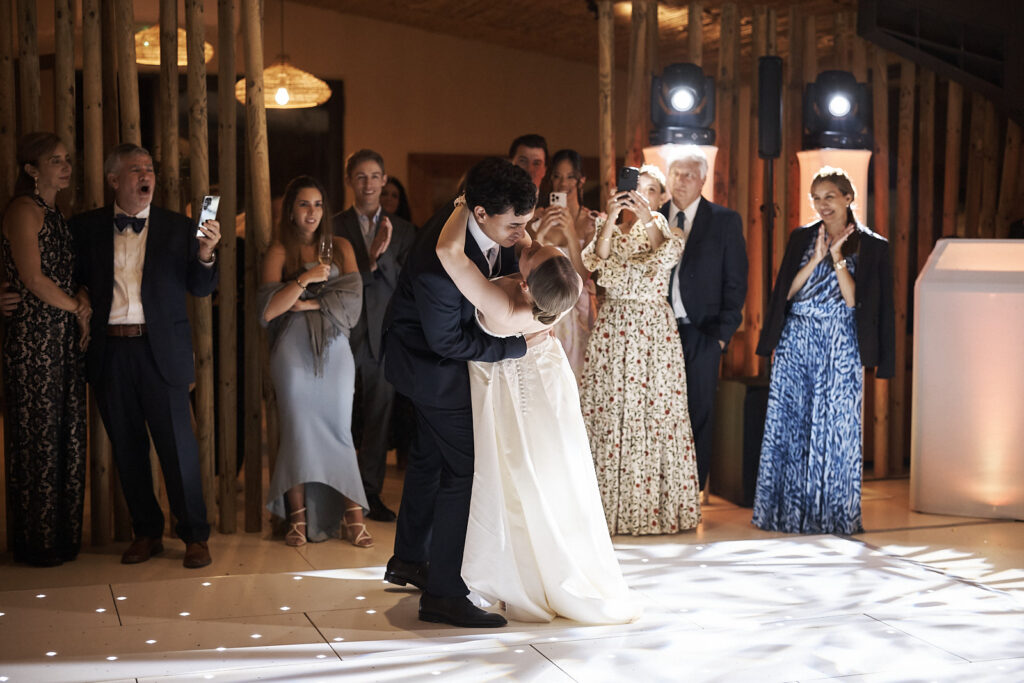 Braut und Bräutigam küssen sich beim Eröffnungstanz im Arvad in der Algarve während die Gäste zusehen