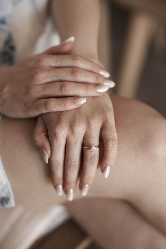 Schwarz-Weiß-Nahaufnahme der Hände der Braut mit Verlobungsring während der Vorbereitungen zur Hochzeit im Weingut Arvad
