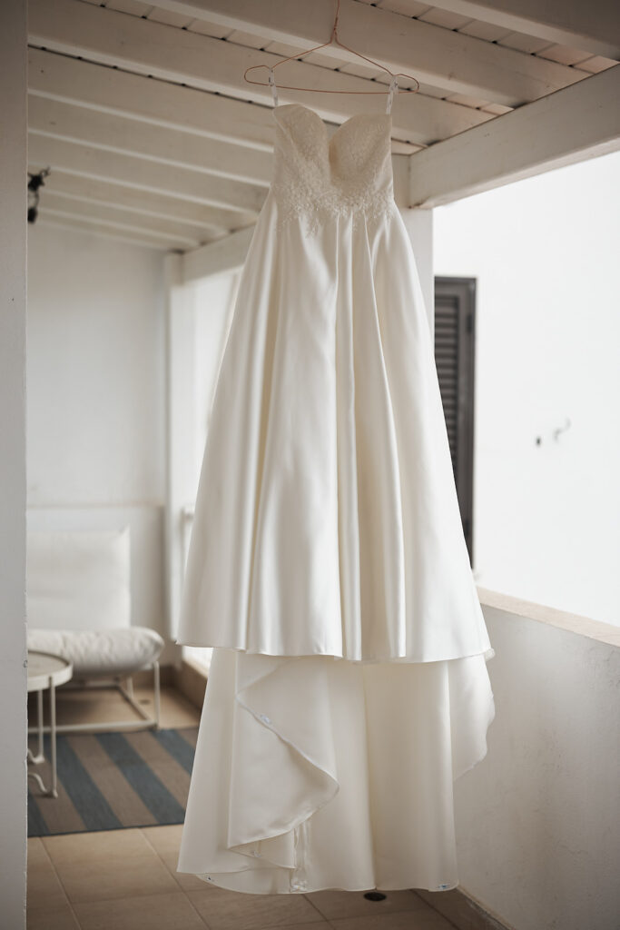 Brautkleid auf einem Bügel aufgehängt vor den Vorbereitungen zur Hochzeit im Weingut Arvad an der Algarve