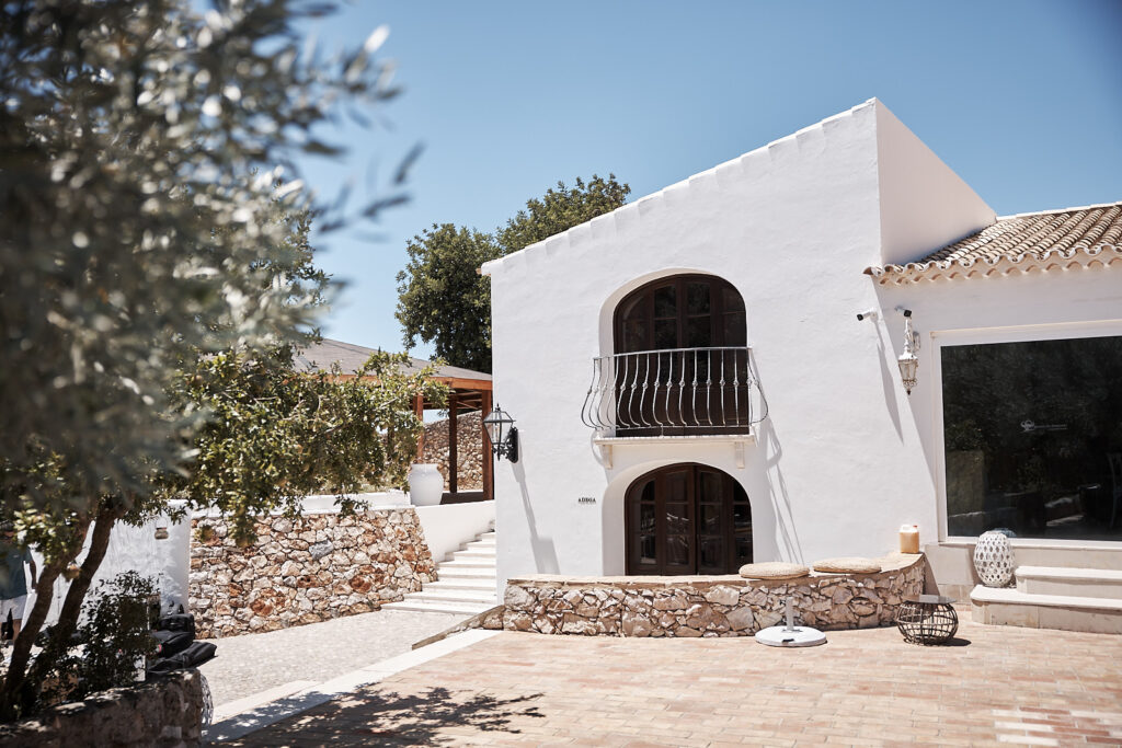 Außenansicht von Monte do Serrinho an der Algarve, Portugal, mit weißer Fassade, Natursteinmauern und Innenhof