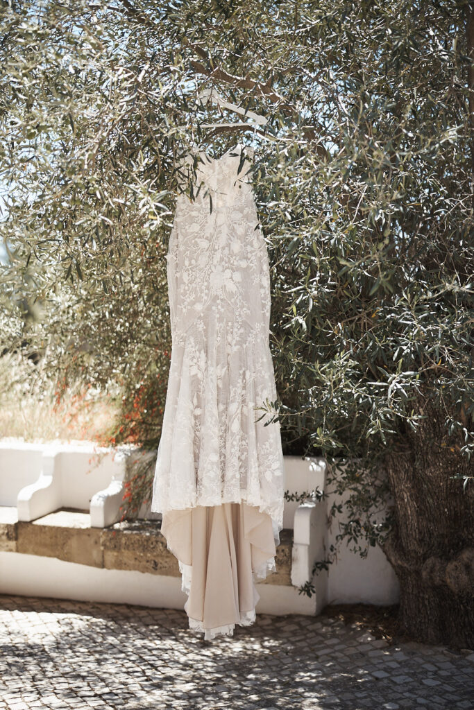 Brautkleid aus Spitze hängt in einem Olivenbaum im Monte do Serrinho an der Algarve, Portugal