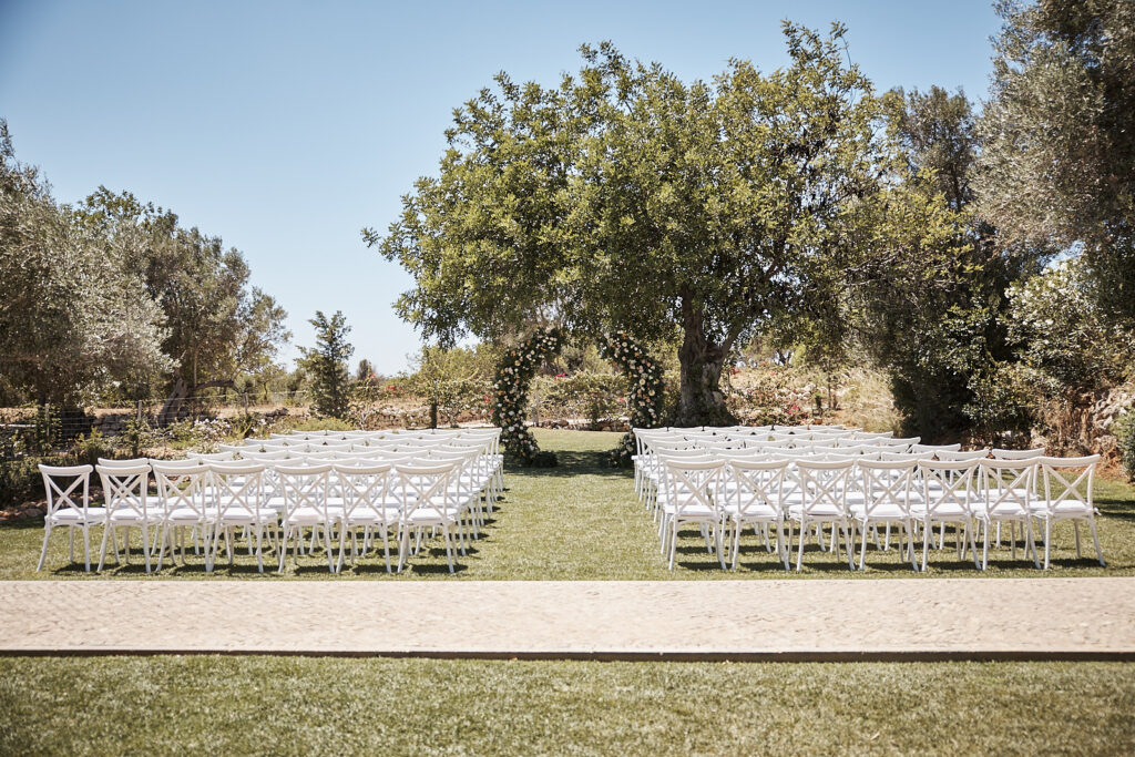 Aufbau der freien Trauung mit weißen Stühlen und Blumenbogen im Monte do Serrinho an der Algarve, Portugal