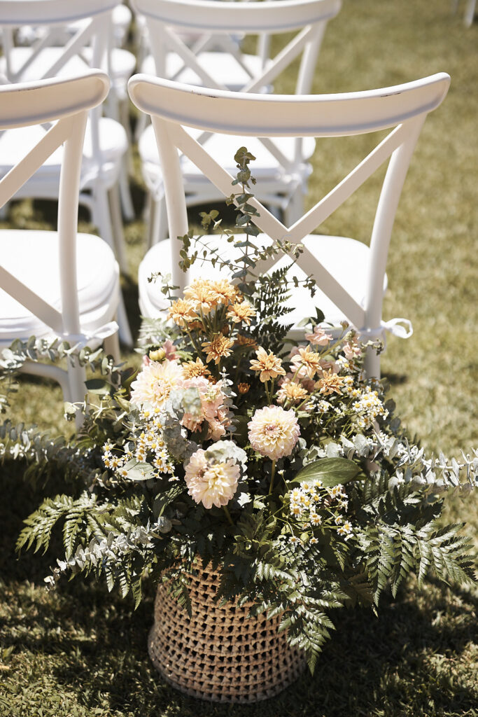 Blumendekoration am Trauungsgang neben weißen Stühlen im Monte do Serrinho an der Algarve, Portugal