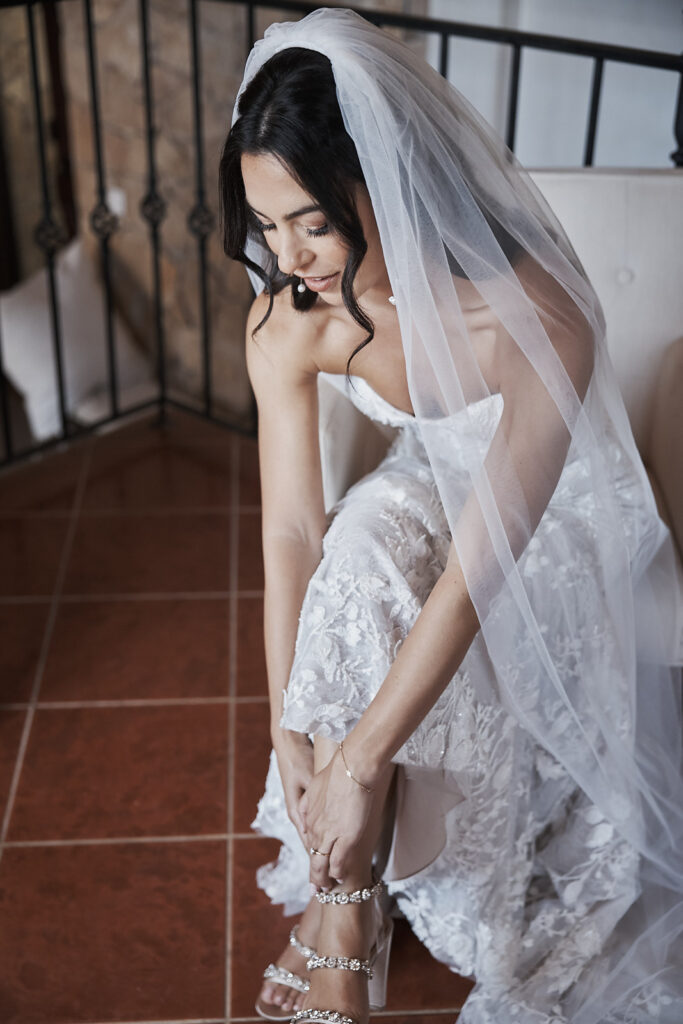 Braut zieht ihren Brautschuh während der Vorbereitungen im Monte do Serrinho an der Algarve, Portugal an