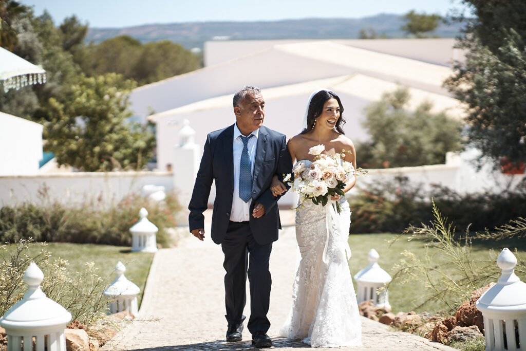 Braut mit ihrem Vater auf dem Weg zur freien Trauung im Monte do Serrinho an der Algarve, Portugal
