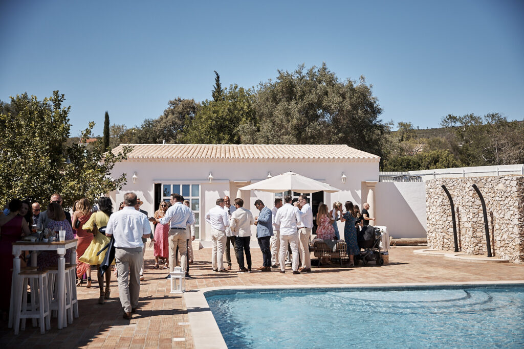 Hochzeitsgäste beim Empfang am Pool der Hochzeitslocation Monte do Serrinho an der Algarve