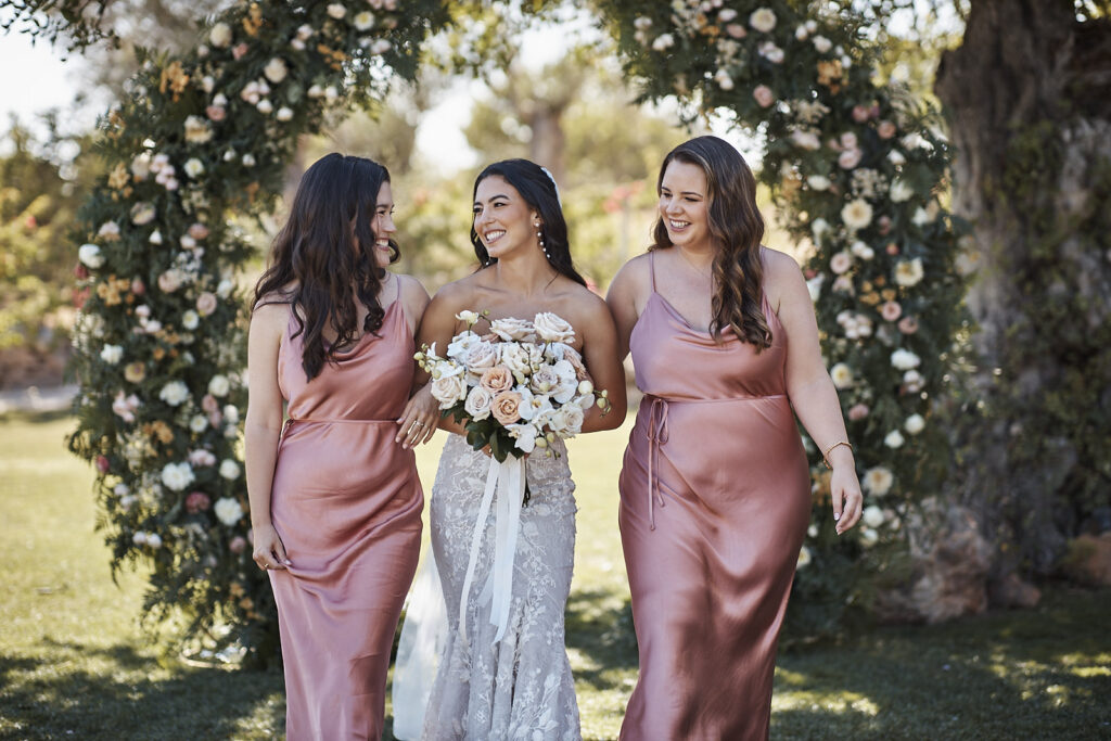 Braut mit zwei Brautjungfern unter dem Blumenbogen nach der Trauung im Monte do Serrinho an der Algarve
