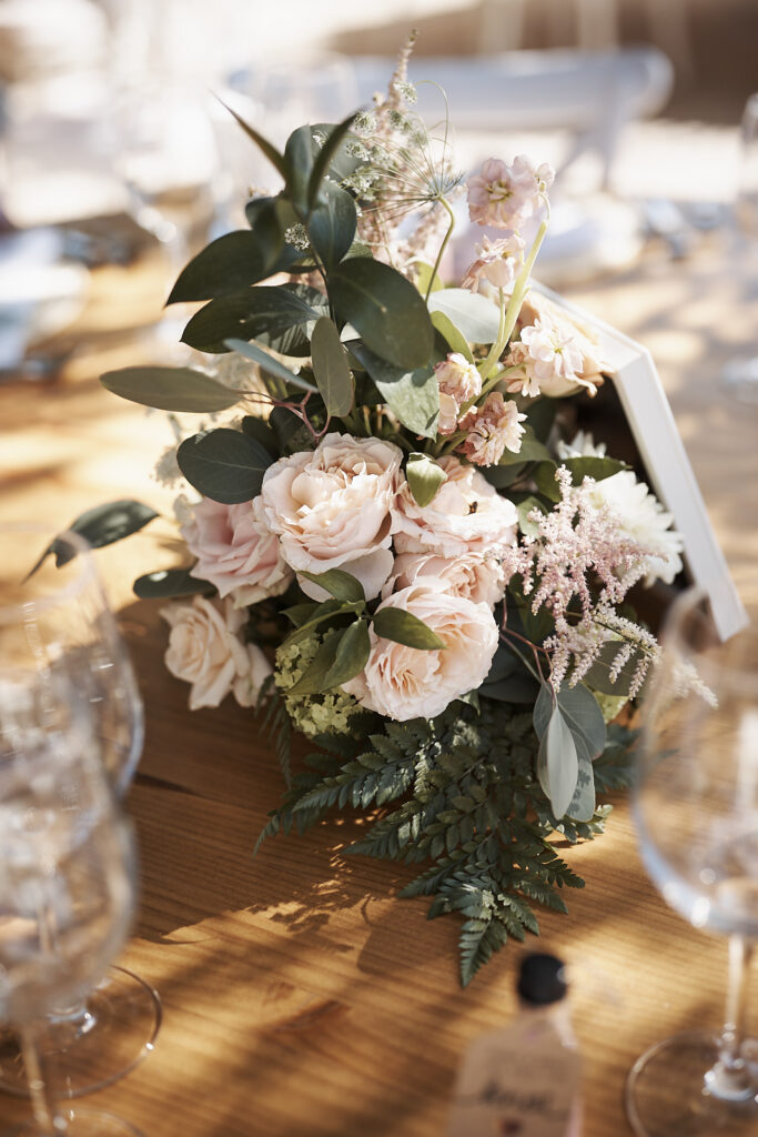 Florales Tischarrangement mit Rosen und grünen Blättern auf einer Hochzeitstafel im Monte do Serrinho an der Algarve