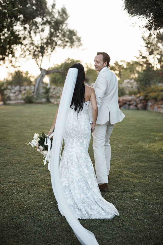 Braut und Bräutigam gehen Hand in Hand über den Garten von Monte do Serrinho an der Algarve