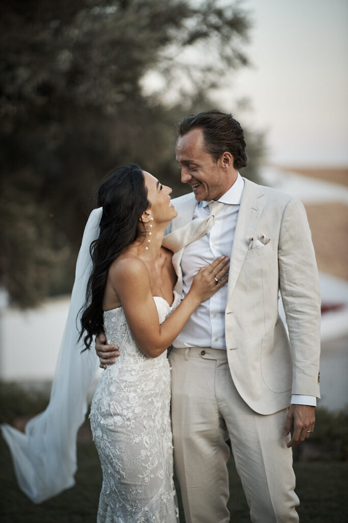 Braut und Bräutigam lachen sich im Garten von Monte do Serrinho an der Algarve liebevoll an
