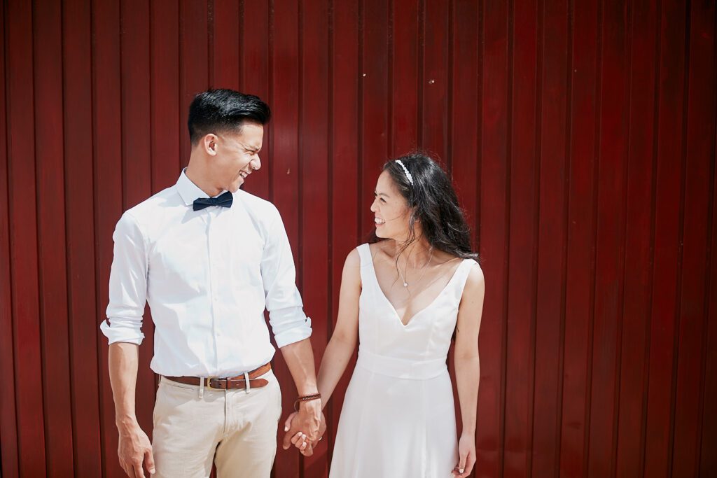 Bride and groom walking through the whitewashed streets of Pedralva village during their Portugal elopement.